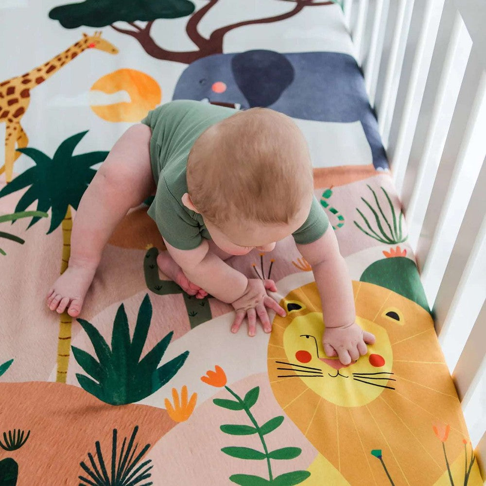 Rookie Humans cotton sateen crib sheet in savanna print with giraffe, lion, and elephant motifs