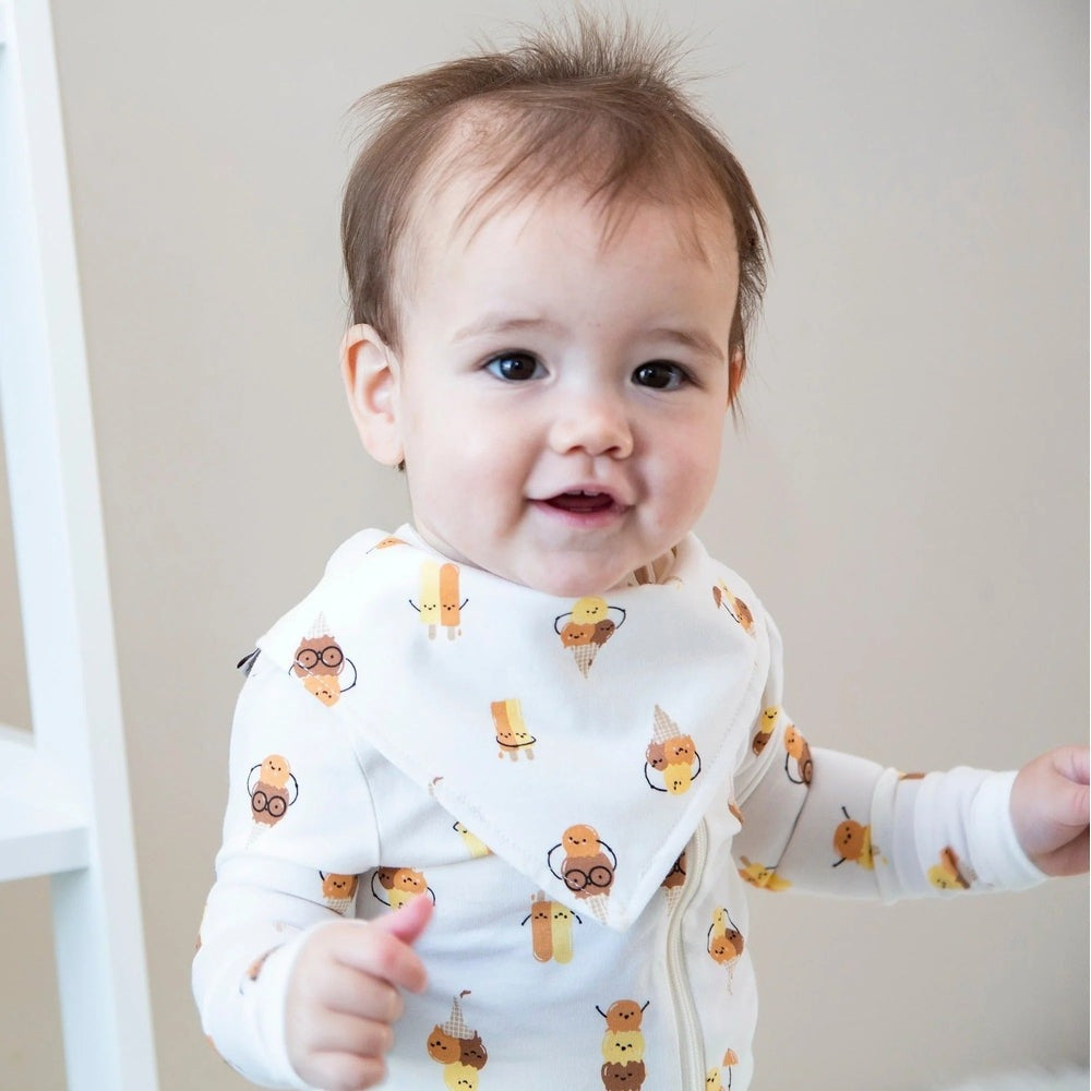Silkberry Baby Organic Cotton Bandana Bib Icy Pals print on white, worn by a smiling toddler