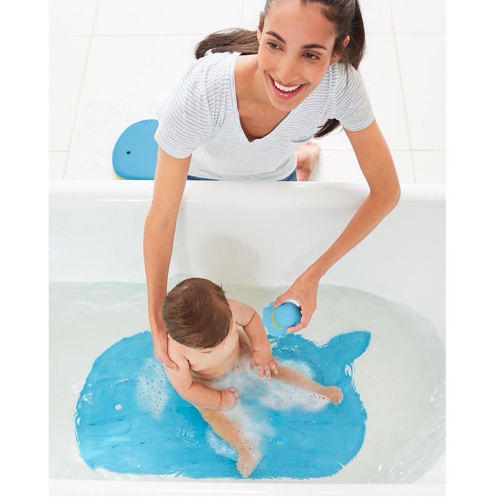 Skip Hop blue bath mat in tub with baby playing on it