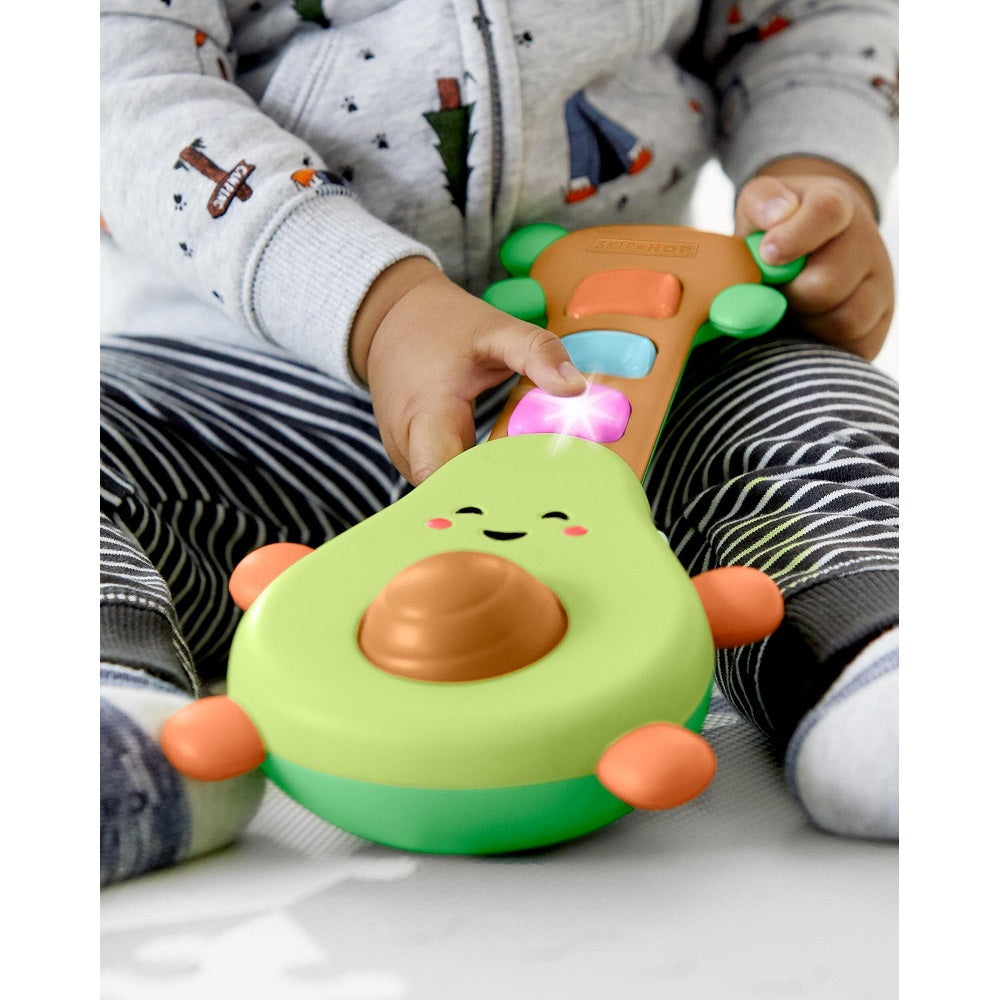 Skip Hop Farmstand Rock A Mole Guitar toy, a green avocado-shaped handheld toy with colorful buttons.