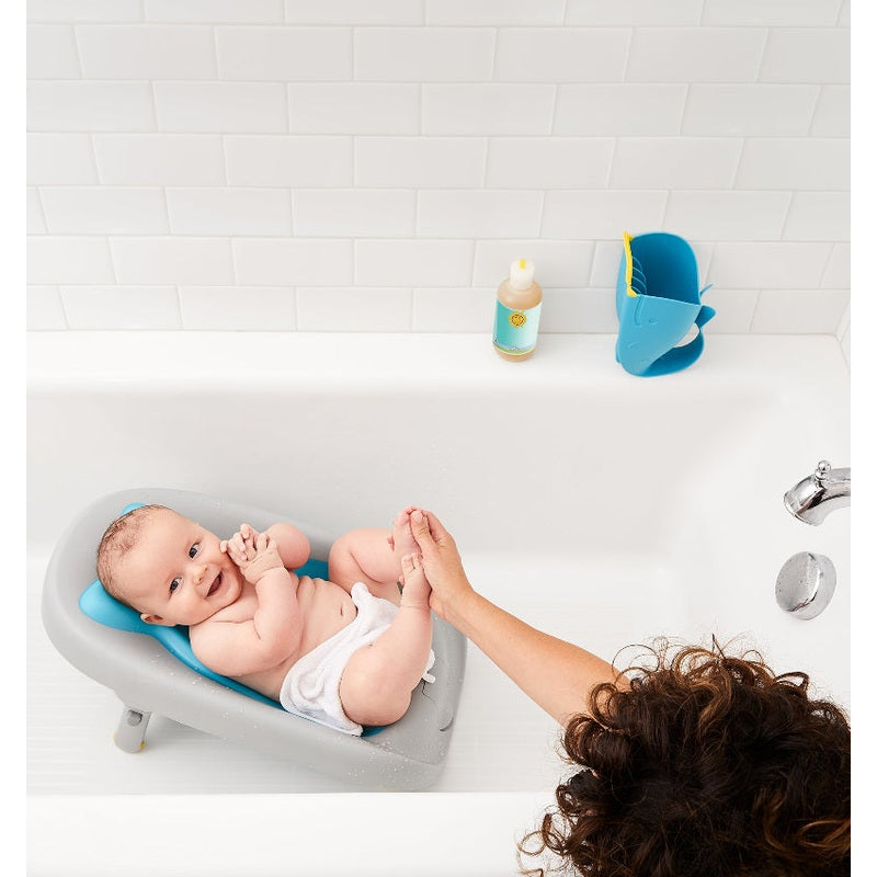 Skip Hop Moby Recline and Rinse Bather in gray tub with blue head support and baby.