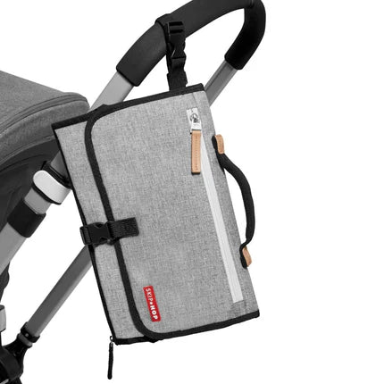 Skip Hop Pronto Signature Changing Station grey melange attached to stroller with straps