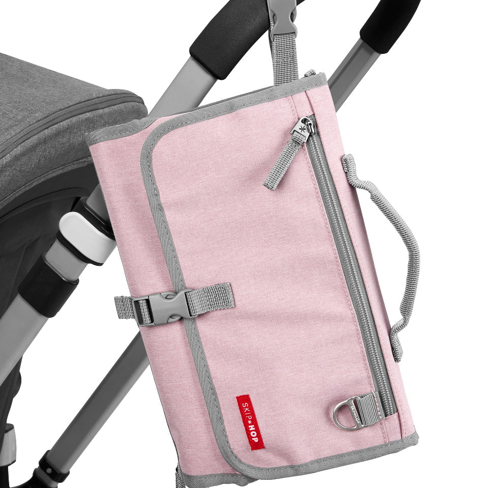 Skip Hop Pronto Signature Changing Station in pink Heather with gray trim attached to stroller, diapering station.