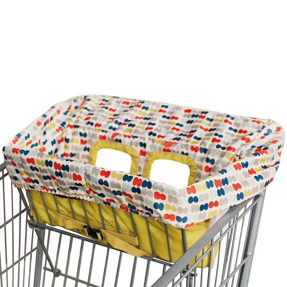 Skip Hop Take Cover Shopping Cart & High Chair Cover in yellow with colorful dot print, draped over a metal shopping cart.