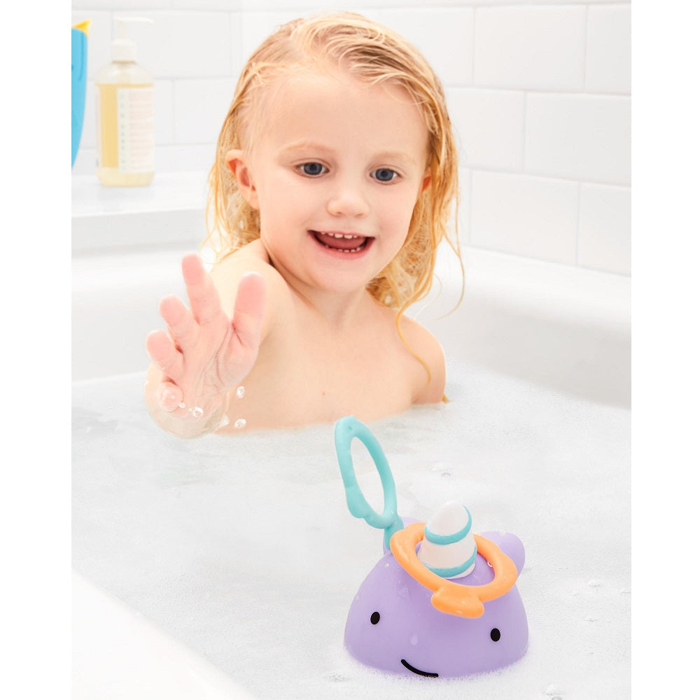 Narwhal Ring Toss bath toy by Skip Hop; purple narwhal with orange ring and teal launcher.