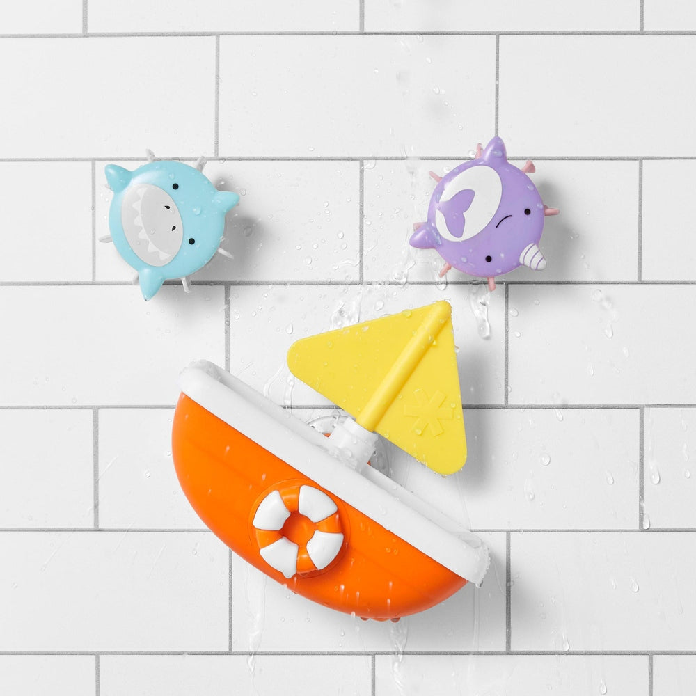 Skip Hop Zoo Tip & Spin Boat bath toy with orange hull, yellow sail and two suction-cup animals