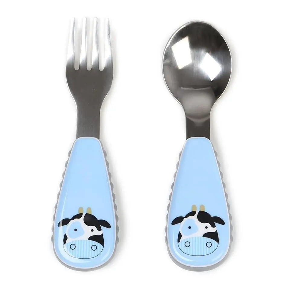 Skip Hop Zoo Utensil Set, blue cow handles shown with a fork and spoon ready for toddler mealtime.