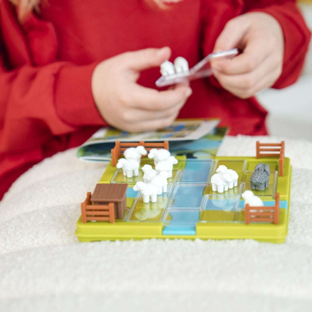 Smart Games Counting Sheep board game with white sheep figures and orange fences on a colorful grid