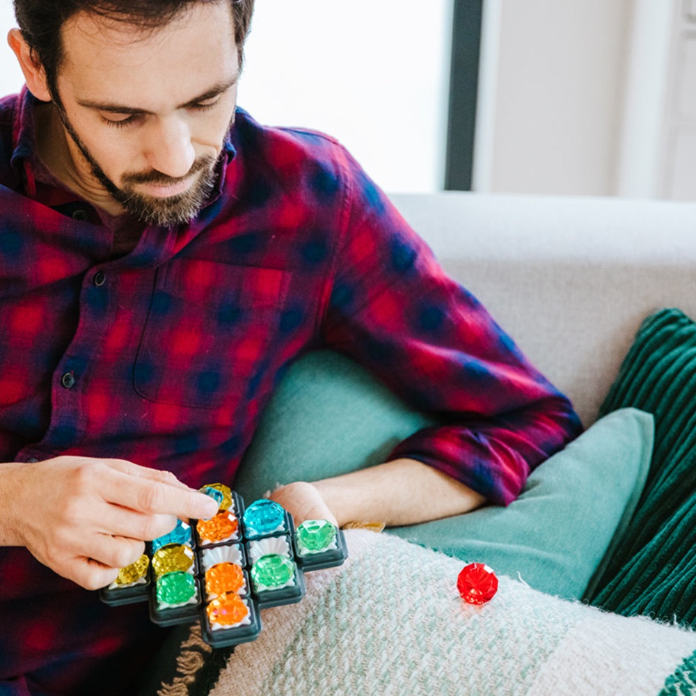 Diamond Quest puzzle by SMART GAMES with colorful gem tiles arranged in a grid on a couch