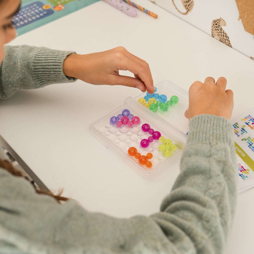 Smart Games IQ Bubbles educational toy featuring bright plastic bubbles arranged in a clear tray