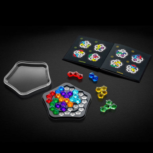 Smart Games IQ Deluxe Pentagon puzzle with colorful gem pieces on a hexagonal tray and instruction booklet