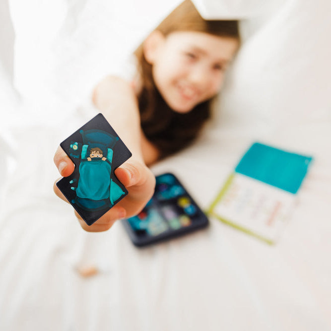 Smart Games Monsters Hide & Seek card game; blue monster card held by child, educational puzzle toy.