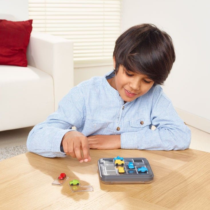 SMART GAMES Parking Puzzler toy with grid and colorful cars; child playing