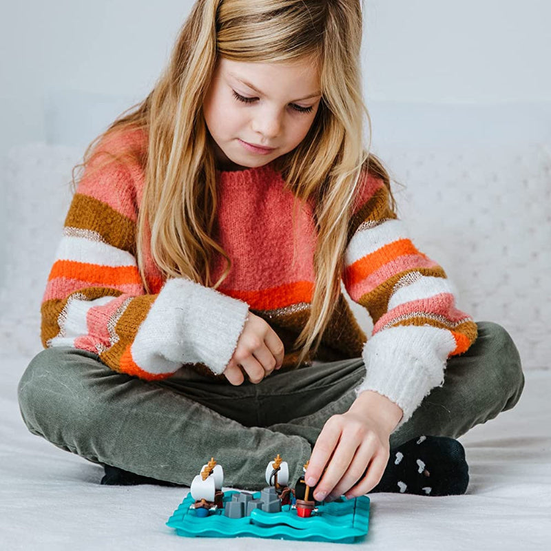 Smart Games Pirates Crossfire educational toy; child plays with pirate figures on a blue game board.