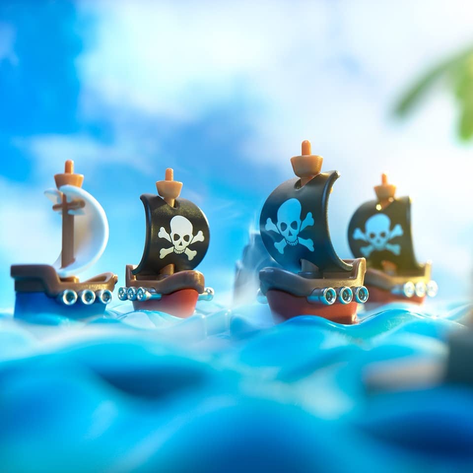 Smart Games Pirates Crossfire toy ships; four plastic pirate ships with black sails and skull icons on blue waves.