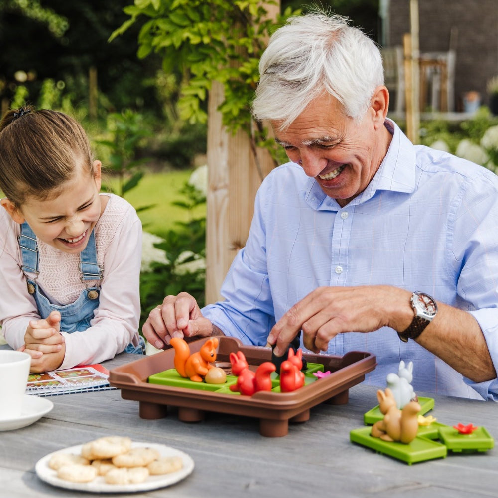 Smart Games Squirrels Go Nuts XXL game with orange and red squirrel figures on brown tray outdoors