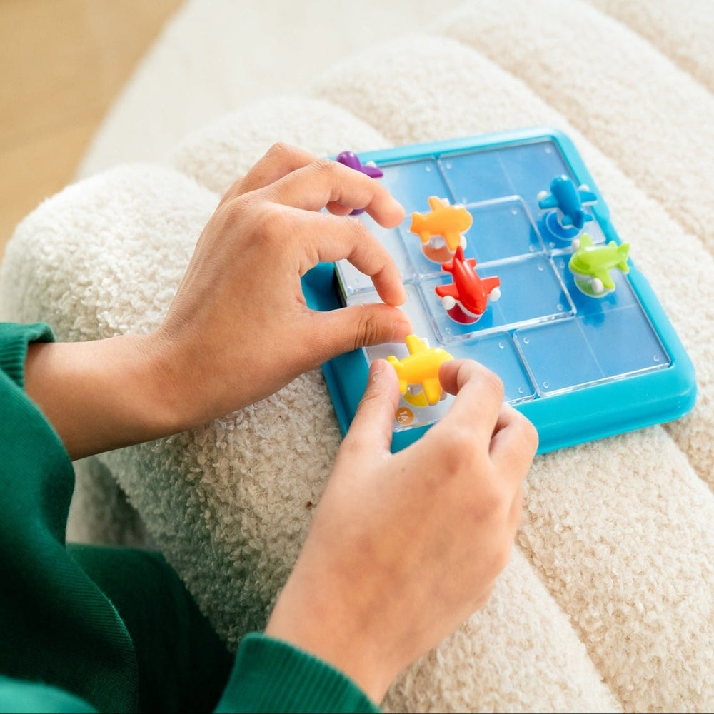 Person playing with a colorful puzzle toy on a soft surface