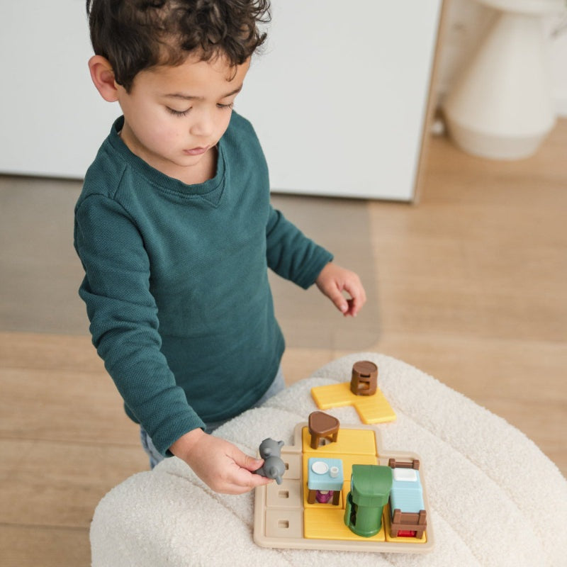 SmartGames Wolf & The Seven Goats wooden puzzle game; toddler playing with colorful modular pieces