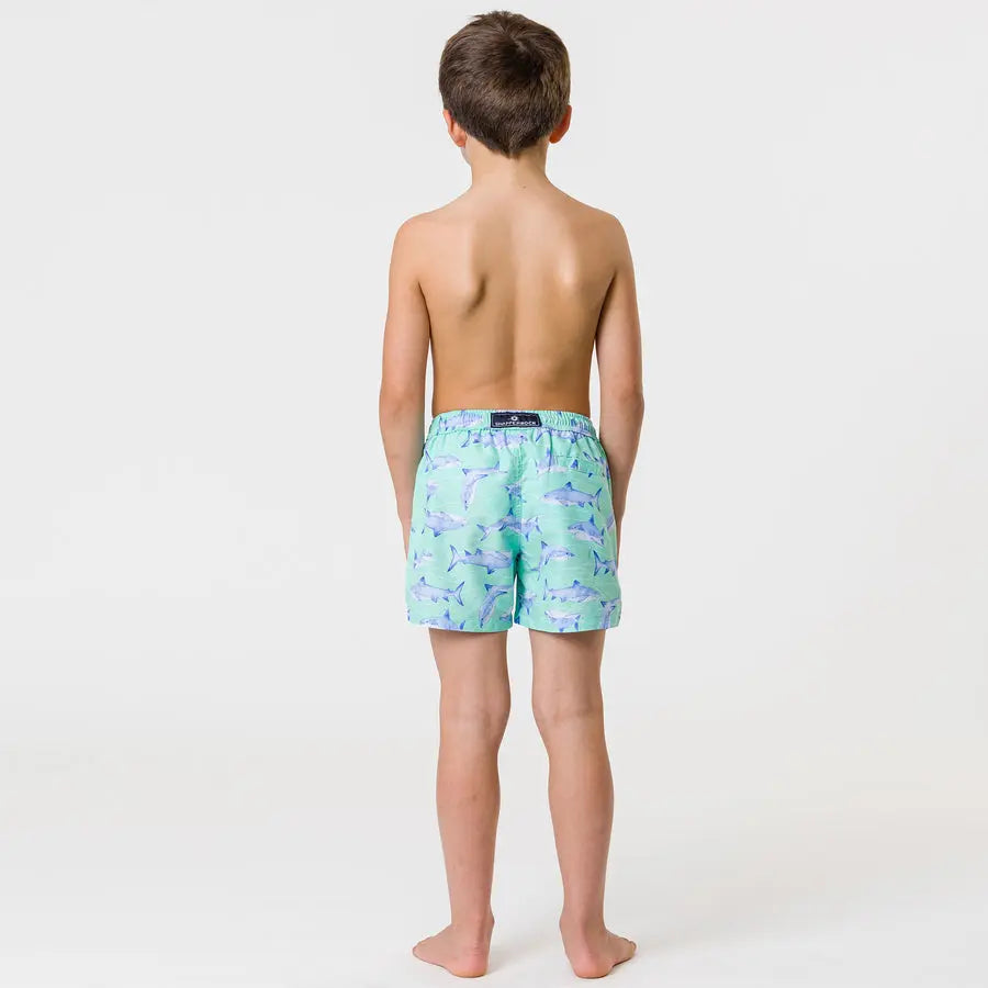 Snapper Rock Minty Shark Volley Board Short for kids, mint green shark print; child stands barefoot, waistband and brand label visible.