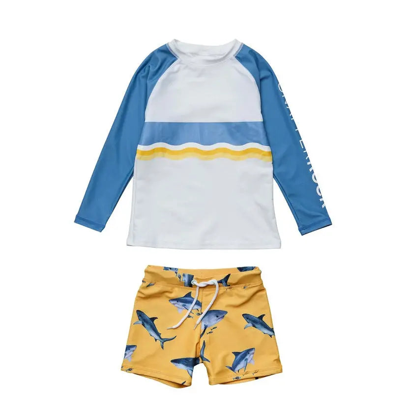 Snapper Rock Sunrise Shark Baby Set: white and blue rash guard with yellow stripe paired with shark-print yellow trunks, laid flat.