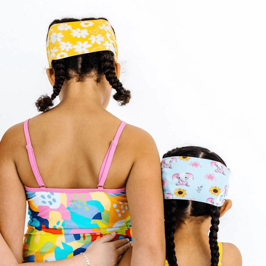 Splash Swim Goggles Ellie; two kids wearing bright floral headbands and colorful swimsuits, back view