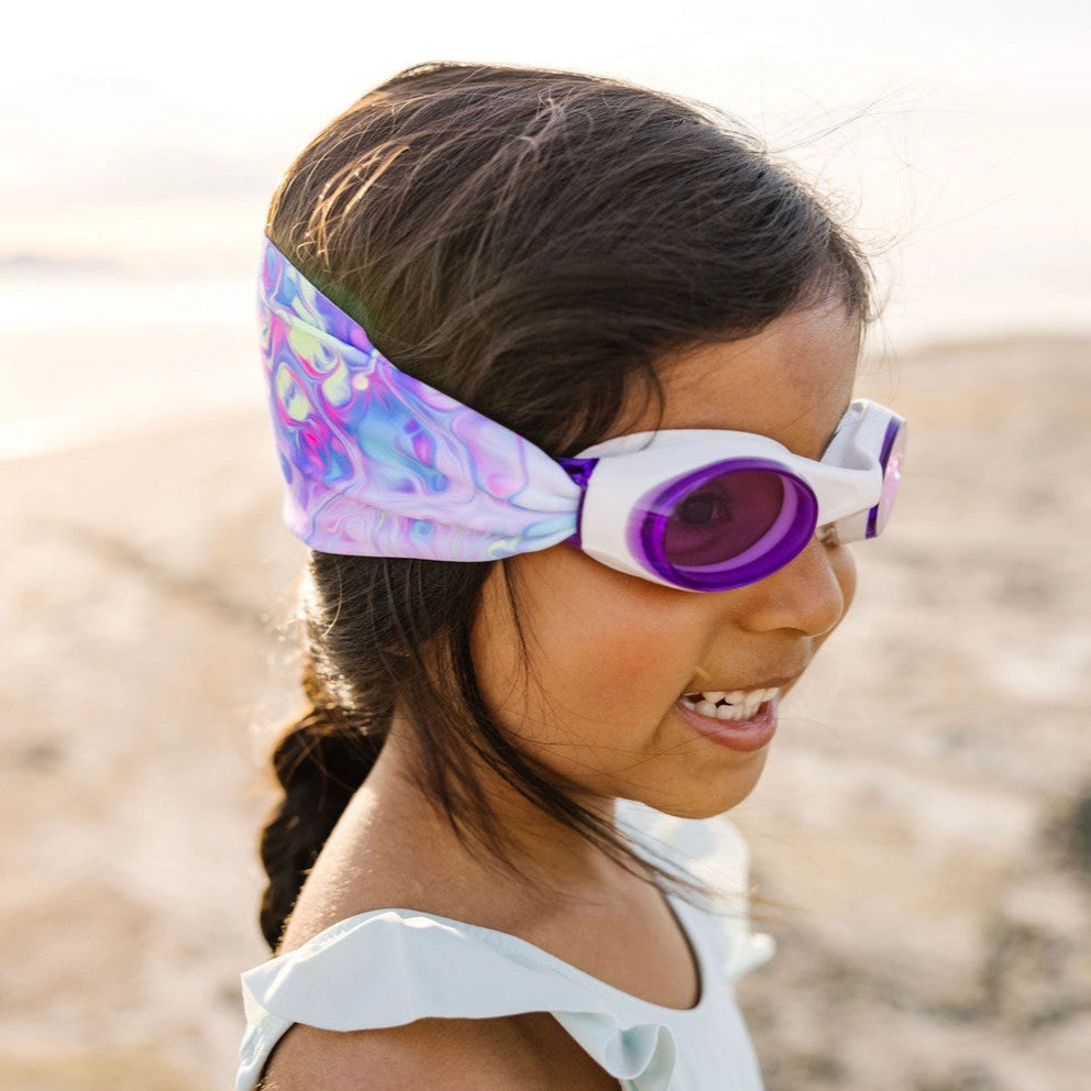 Splash Swim Goggles Pastel Swirl with purple lenses worn by girl at the beach