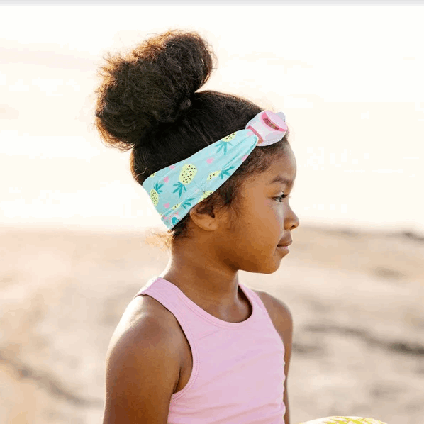 Splash Swim Goggles Pineapple Crush by Splash worn by a girl on the beach with a turquoise pineapple-print headband