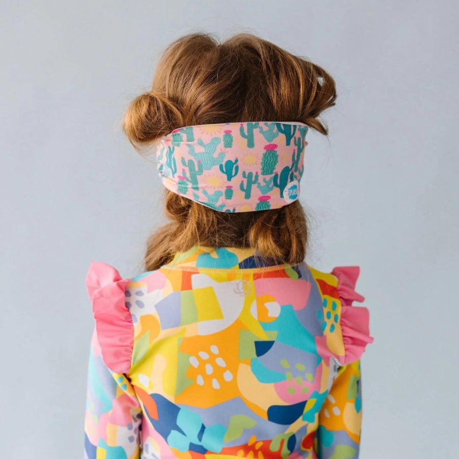 Splash Swim Mask Goggles Desert for kids; pink cactus-pattern headband and a bright multicolor swimsuit with ruffled shoulders.