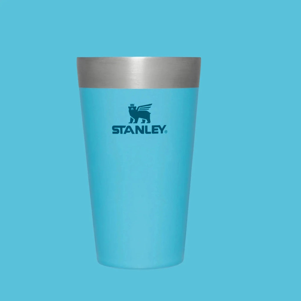 Stanley Adventure Stacking Beer Pint 16 oz turquoise tumbler with silver rim against blue backdrop