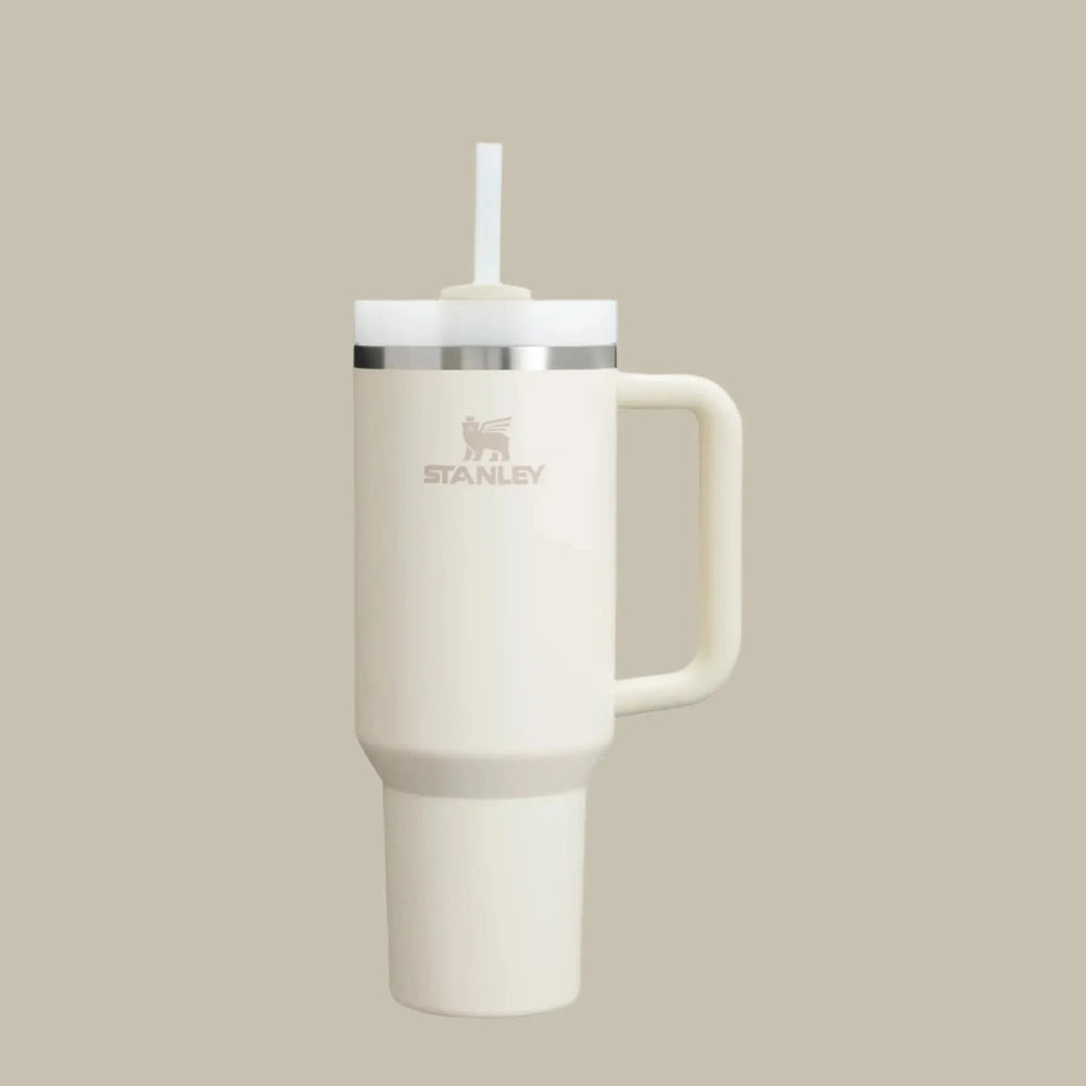 Stanley The Quencher H2.0 Flowstate Tumbler 40 oz cream with straw lid and handle, straw inserted for sipping