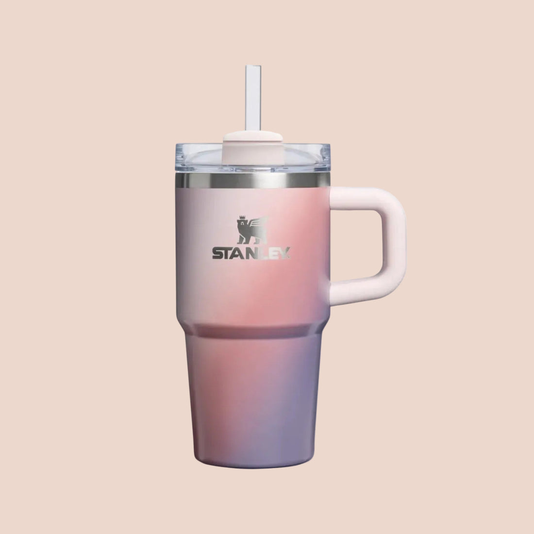 Stanley insulated travel tumbler with a handle, clear lid, and straw. The tumbler features a pink-to-purple gradient finish with a silver metallic band and the Stanley logo on the front.