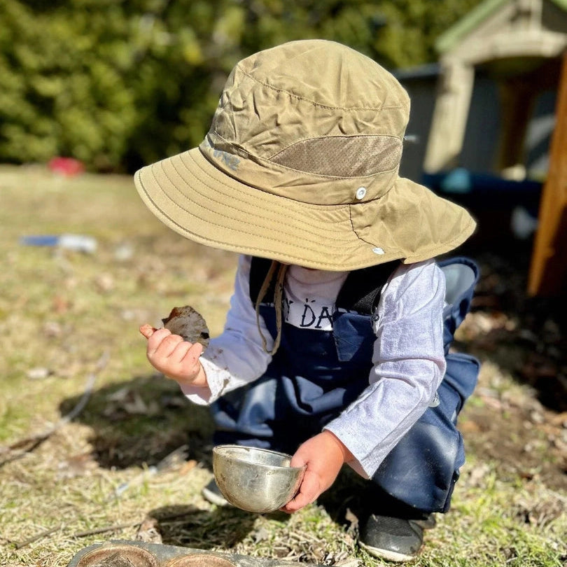 Stonz Explorer Hat Ivory toddler sun hat in beige fabric worn by a young child outdoors.