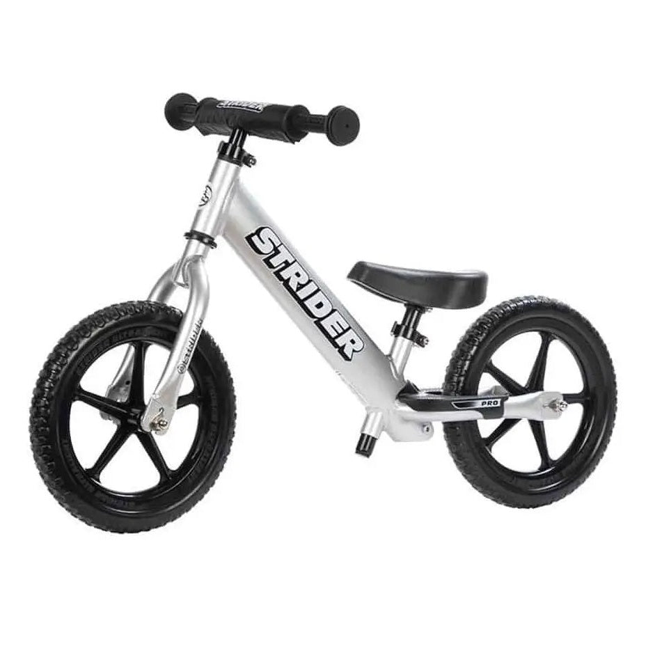 Strider 12 Pro balance bike with silver frame, black five-spoke wheels, and padded handlebars.