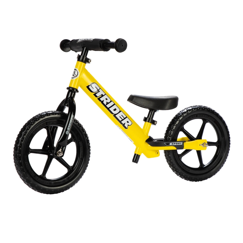 STRIDER 12 Sport balance bike in yellow with black wheels and padded saddle, shown on white background.