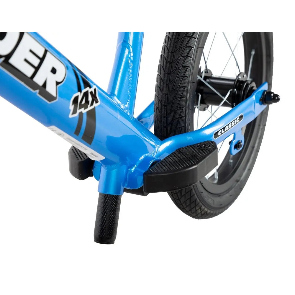 Strider 14X Classic balance bike in blue, with black textured pedals and tires, ready for balance practice.