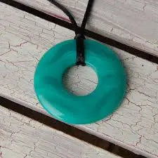 Teethease Original Pendant teal silicone teething necklace hangs from black cord.