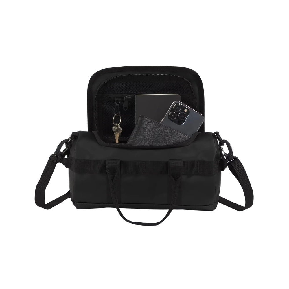 The North Face Base Camp Duffel Shoulder Bag in Black, open top with mesh pocket and visible phone, wallet, and keys.