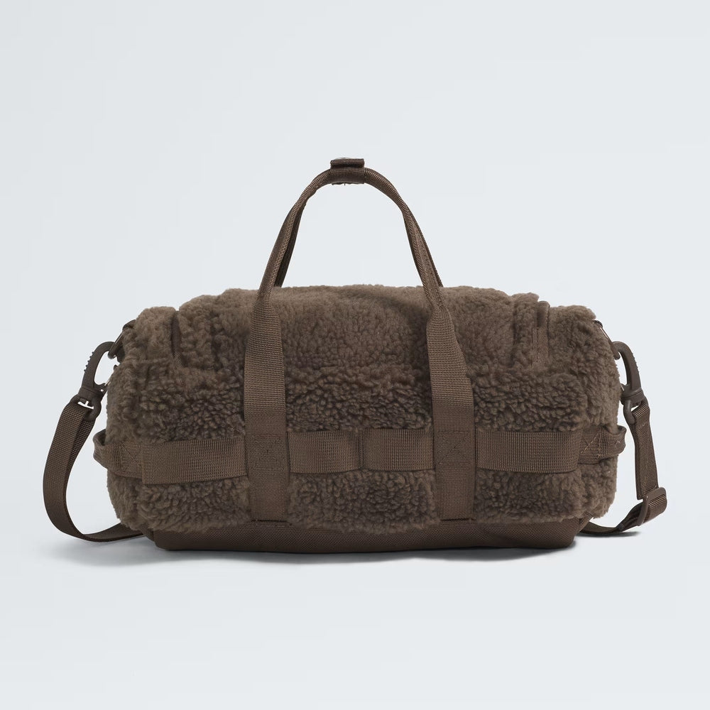 The North Face Base Camp High Pile mini bag in brown faux shearling with carry handles and adjustable strap.