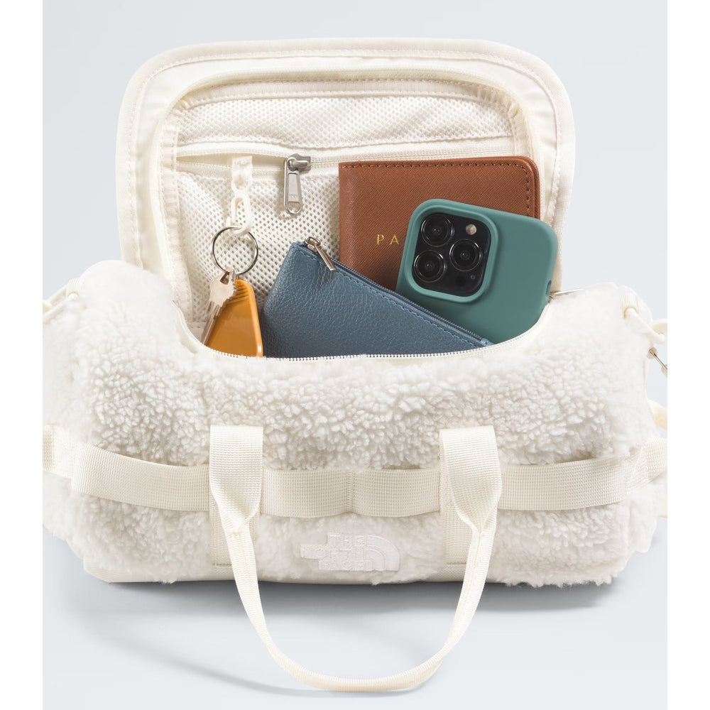 The North Face Base Camp High Pile Mini Bag in cream fleece with two handles, open main compartment showing phone and wallet.