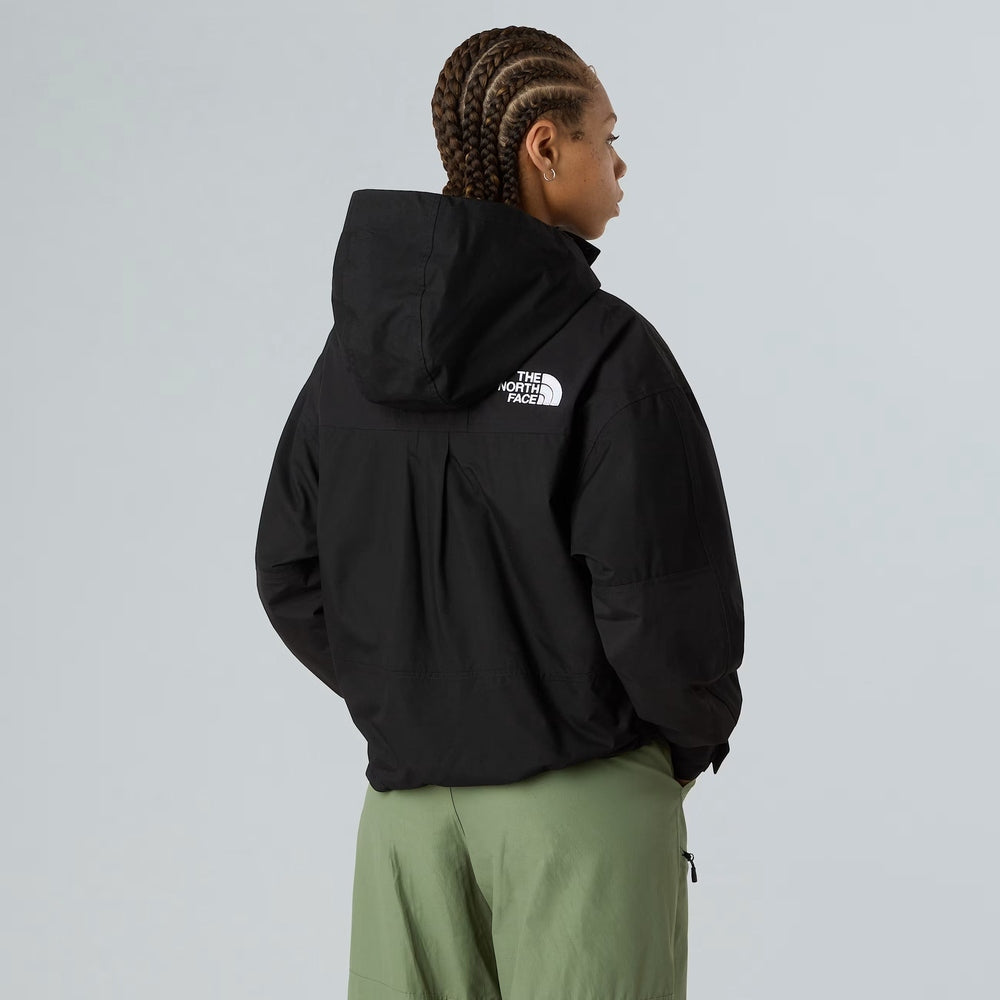 The North Face Women’s Reign On jacket in black raincoat with hood and white logo on back.
