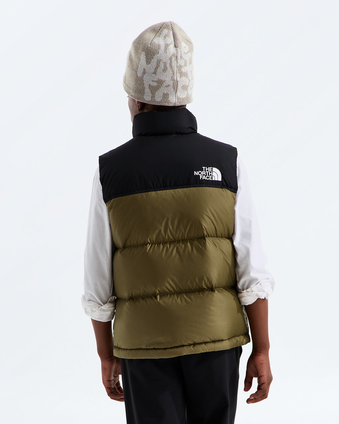 The North Face kids’ 1996 Retro Nuptse Vest in Caraway Seed, back view with embroidered shoulder logo
