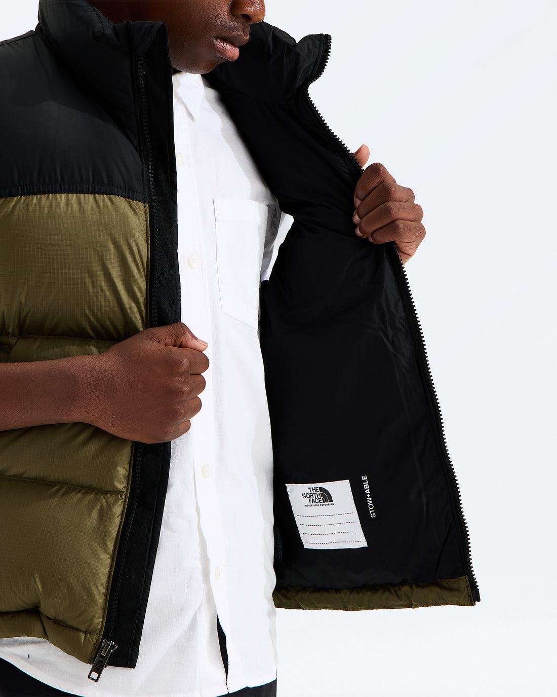 Interior draft flap and ID label detail on the Caraway Seed 1996 Retro Nuptse Vest for kids