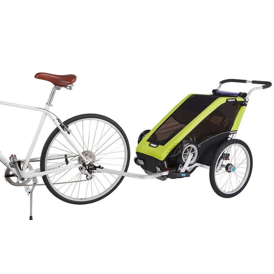 Thule Chariot Cheetah Xt bike trailer in lime green and black hitched to a silver bicycle for an active family outing.