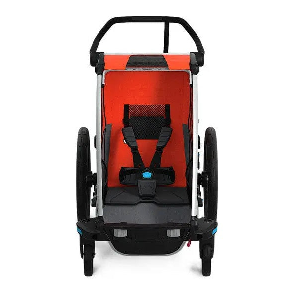 Thule Chariot Cross bicycle trailer, white frame, orange interior, five-point harness secured.