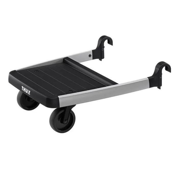 Thule Glider Board stroller accessory, black platform with silver rails and wheels, attached to a stroller