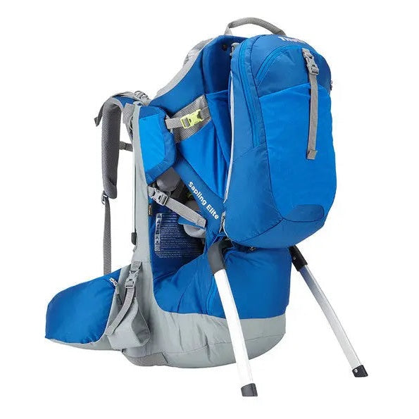 Thule Sapling Elite Child Carrier in blue/gray with adjustable frame; kickstand props the carrier for hiking.