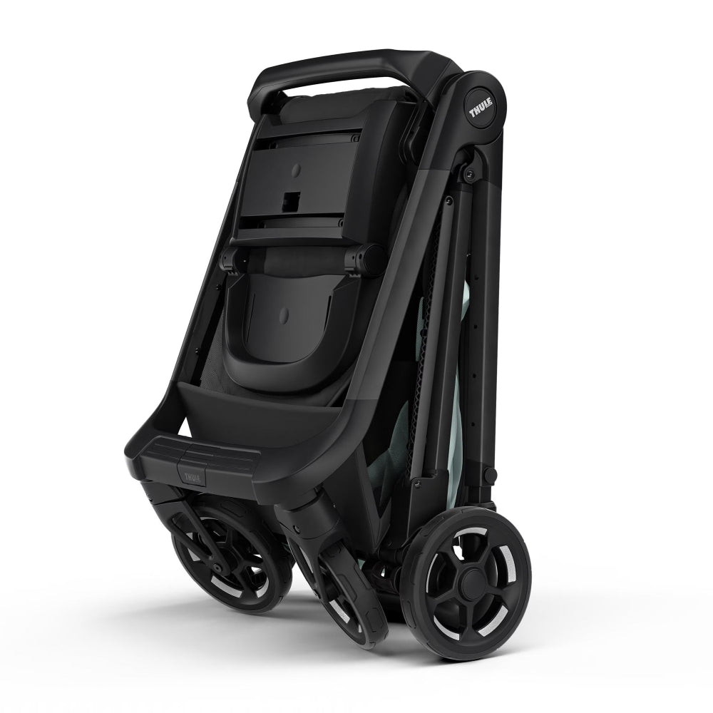 Thule Shine stroller folded compactly with black frame and wheels