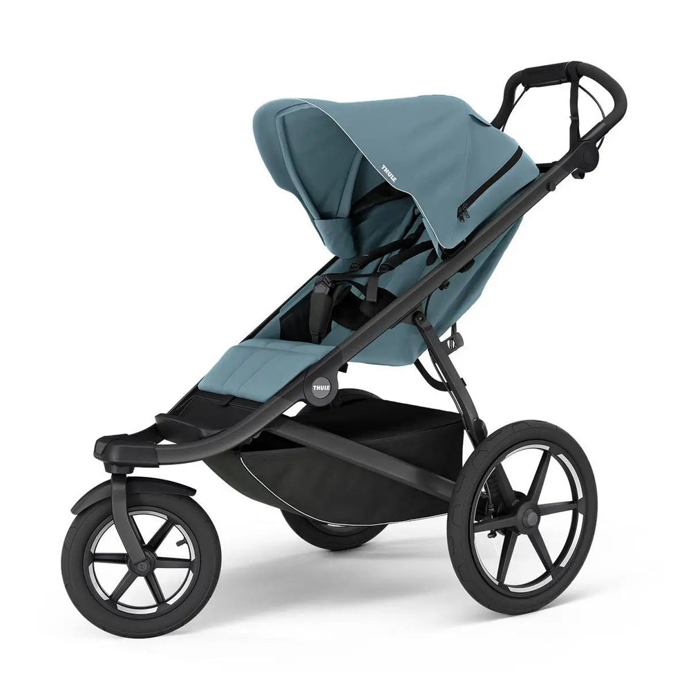 Thule Urban Glide 3 stroller in teal canopy with black frame and large wheels, shown ready for a smooth urban stroll.