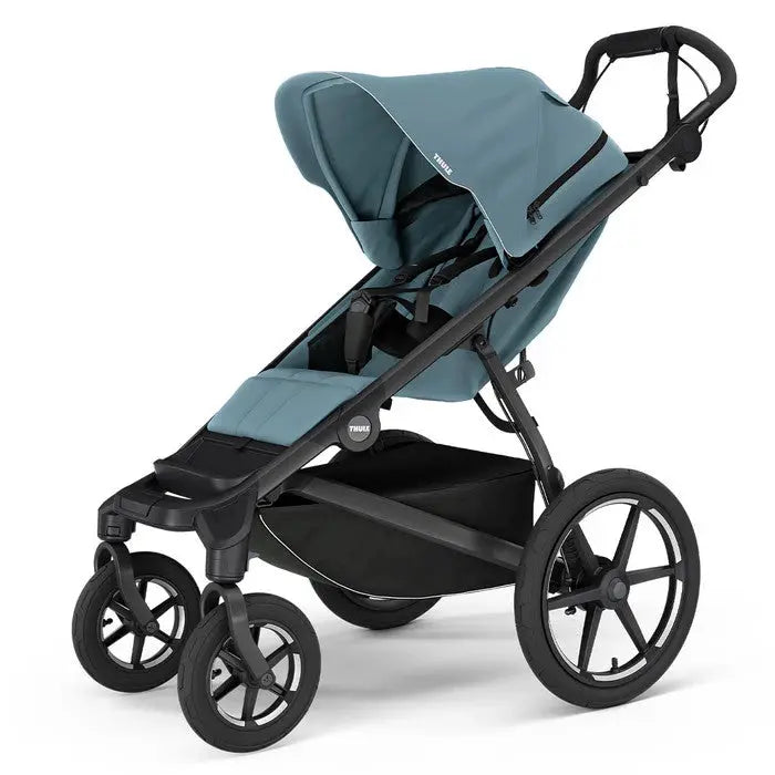 Thule Urban Glide 4-Wheel stroller in teal with black frame and extended canopy, ready for an urban stroll.