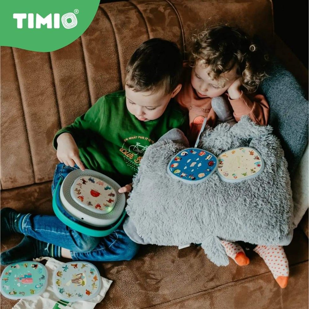 Timio Player Starter Kit with blue-green disc player and colorful discs; two kids on a brown couch
